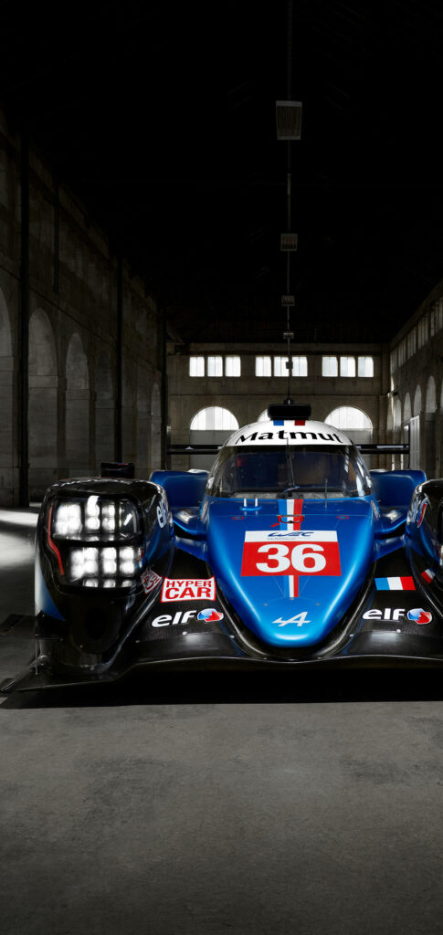 Front view of Alpine Car 36 racing car with aerodynamic design in industrial garage setting Wallpaper