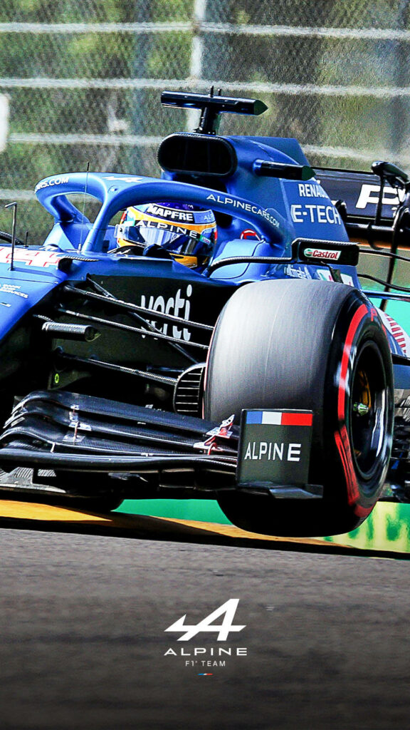 Close-up of Alpine F1 car tire with logo spinning fast capturing intense Formula 1 racing action Wallpaper
