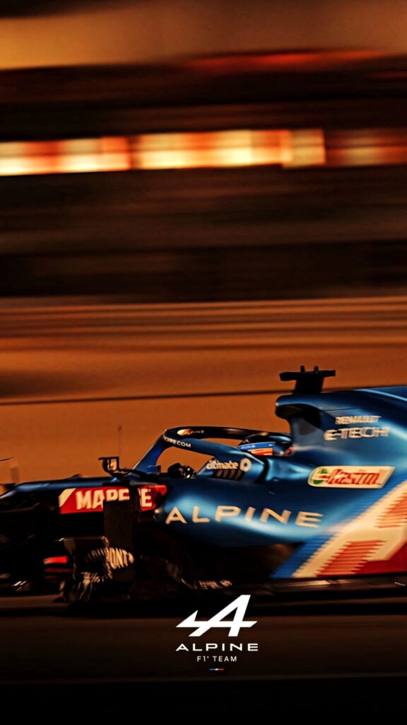 Alpine F1 car speeding on racetrack with motion blur and iconic blue livery wallpaper background