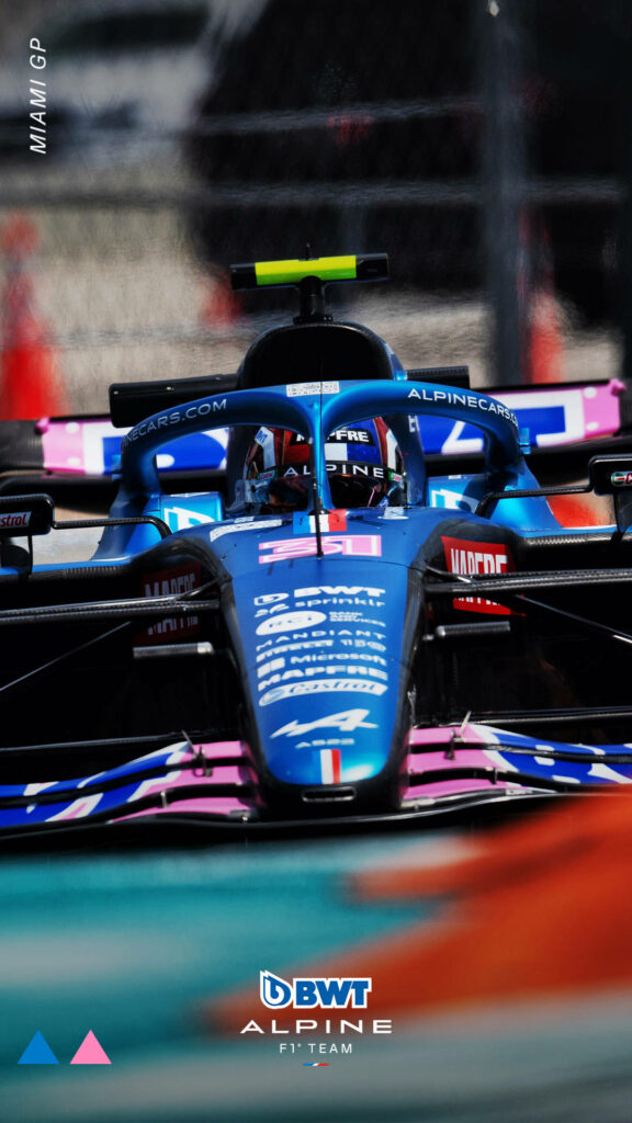 Alpine Formula 1 car with pink accents racing at Miami Grand Prix detailed wallpaper background