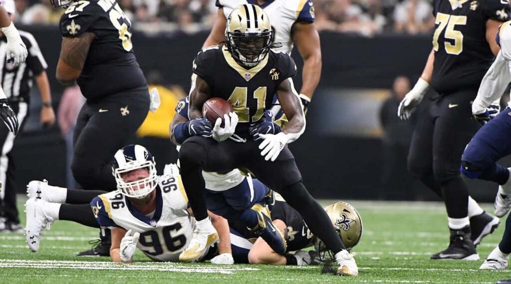 Alvin Kamara running strong with the ball for New Orleans Saints dynamic NFL running back Wallpaper