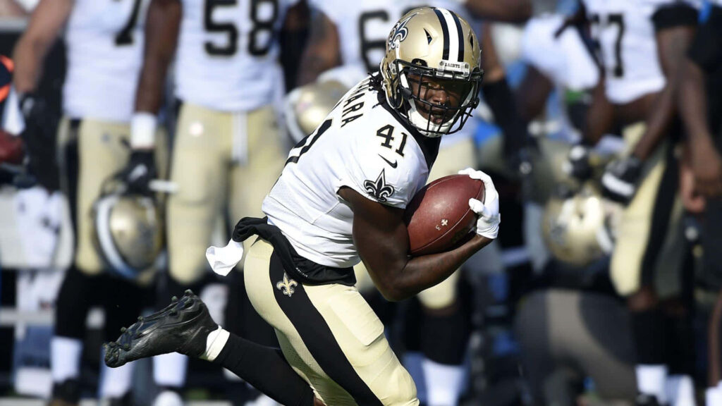 Alvin Kamara in New Orleans Saints uniform running with football during game action wallpaper