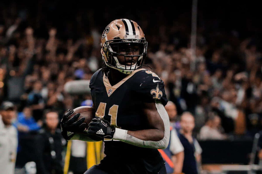 Alvin Kamara New Orleans Saints running dynamic football action vivid wallpaper background