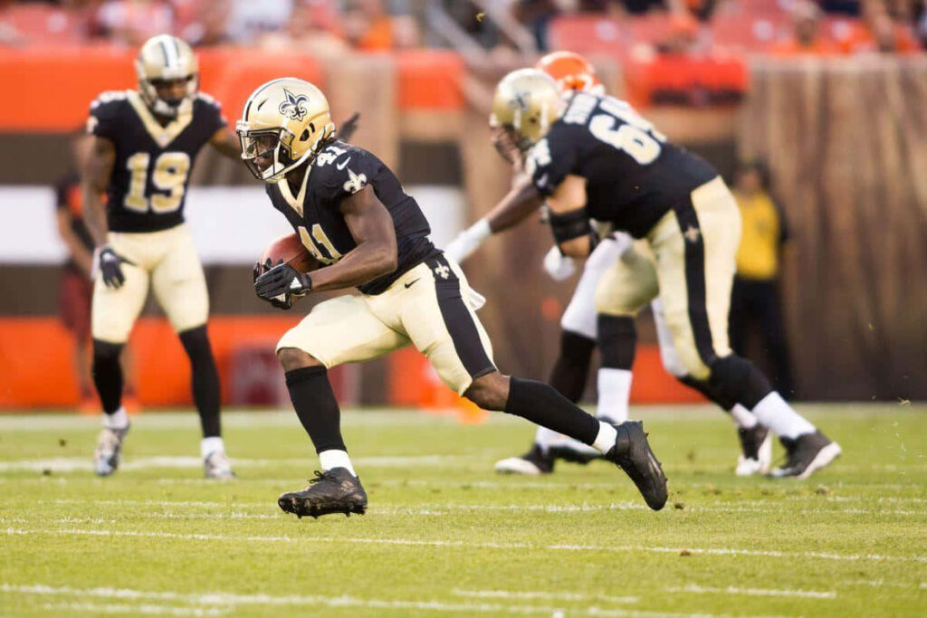 Alvin Kamara NFL Saints running back in black and gold uniform focused during game play Wallpaper
