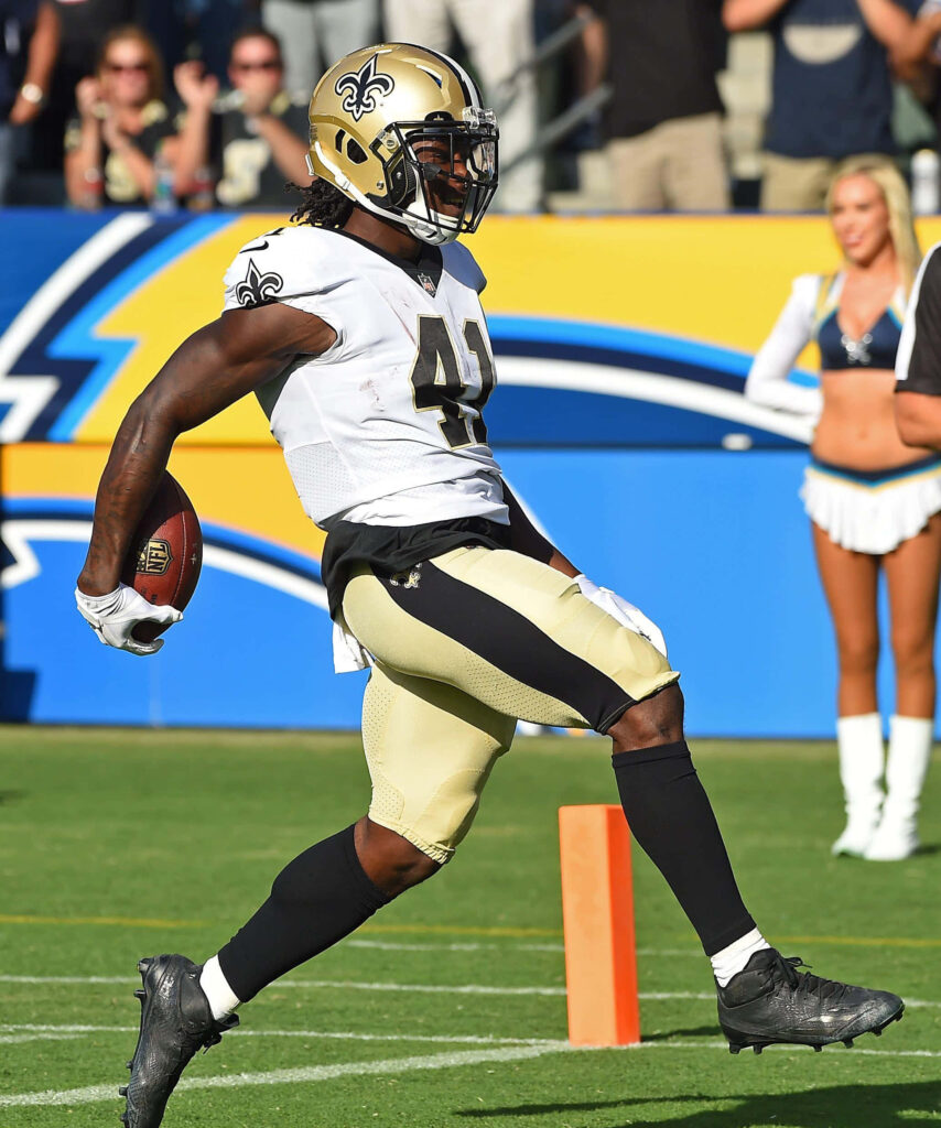 Alvin Kamara scores a touchdown in New Orleans Saints uniform with cheerleaders behind Wallpaper