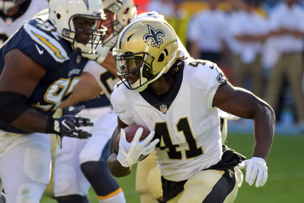 Alvin Kamara New Orleans Saints charges with football evading defenders celebrating touchdown Wallpaper