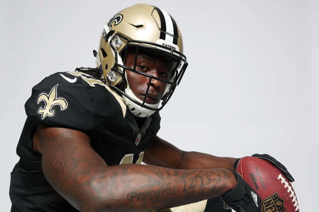 Alvin Kamara New Orleans Saints running back holding football focused NFL wallpaper background
