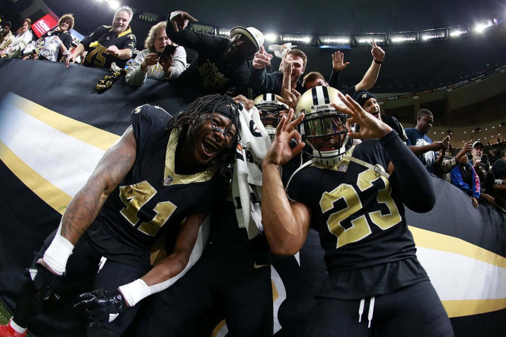 Alvin Kamara celebrates his touchdown with New Orleans Saints teammates and fans in the end zone Wallpaper