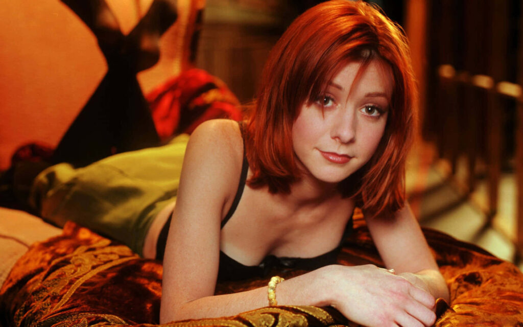 Alyson Hannigan portrait with signature red hair soft inviting expression warm intimate setting Wallpaper
