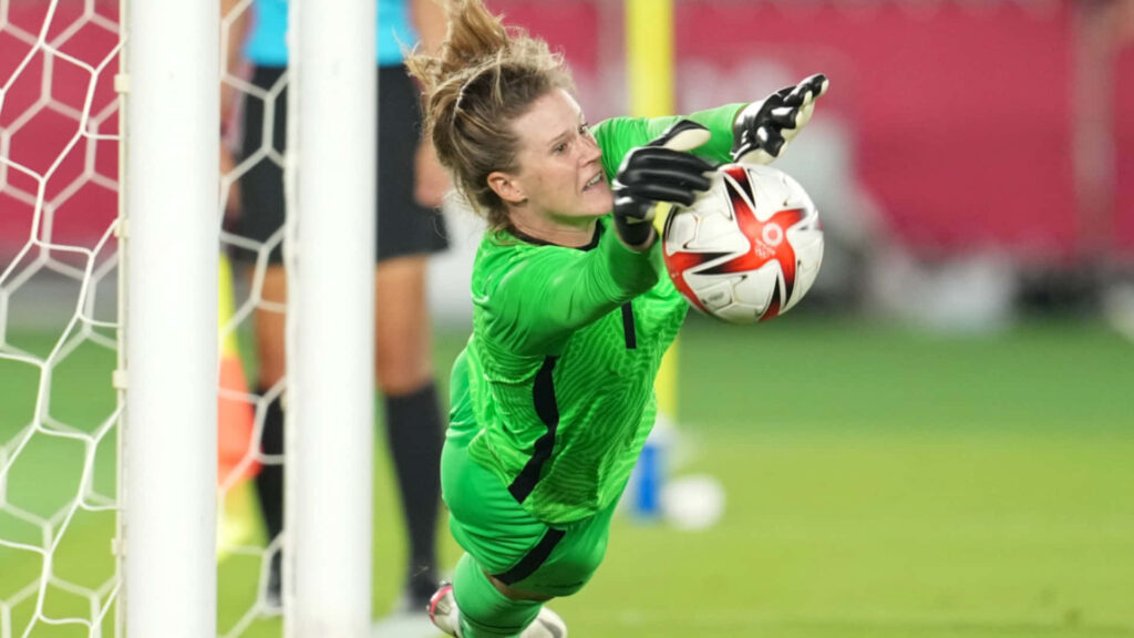 Alyssa Naeher diving save intense soccer match focused goalkeeper action wallpaper background