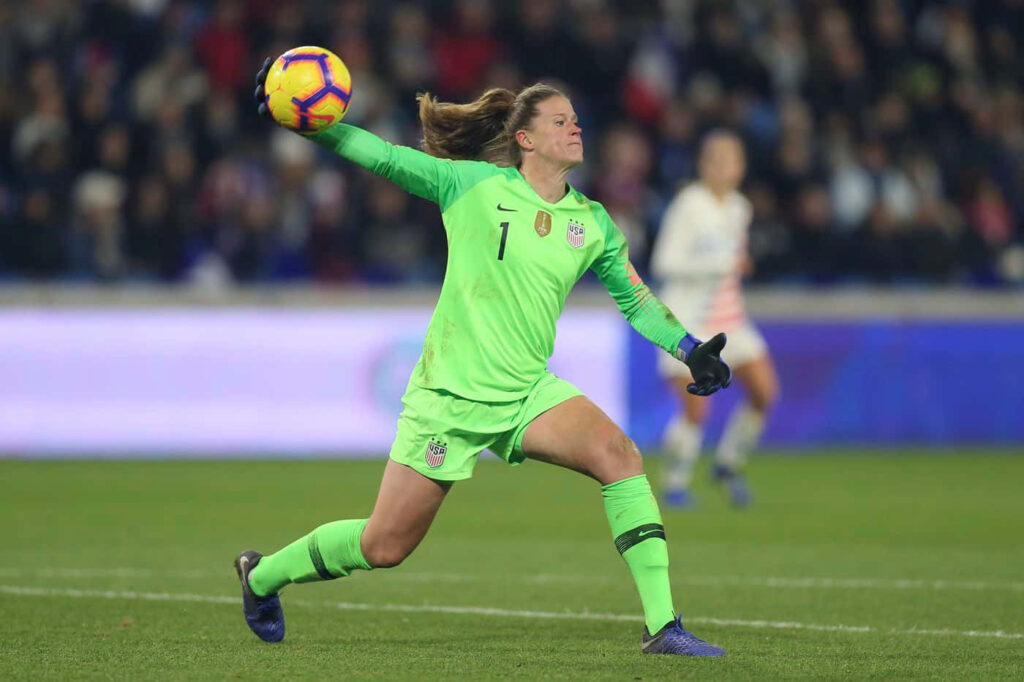 Alyssa Naeher goalkeeper throwing ball during intense soccer match showcasing her skills wallpaper