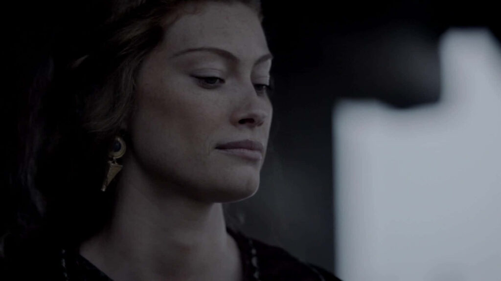 Alyssa Sutherland in a thoughtful pose with dark backdrop striking introspective wallpaper