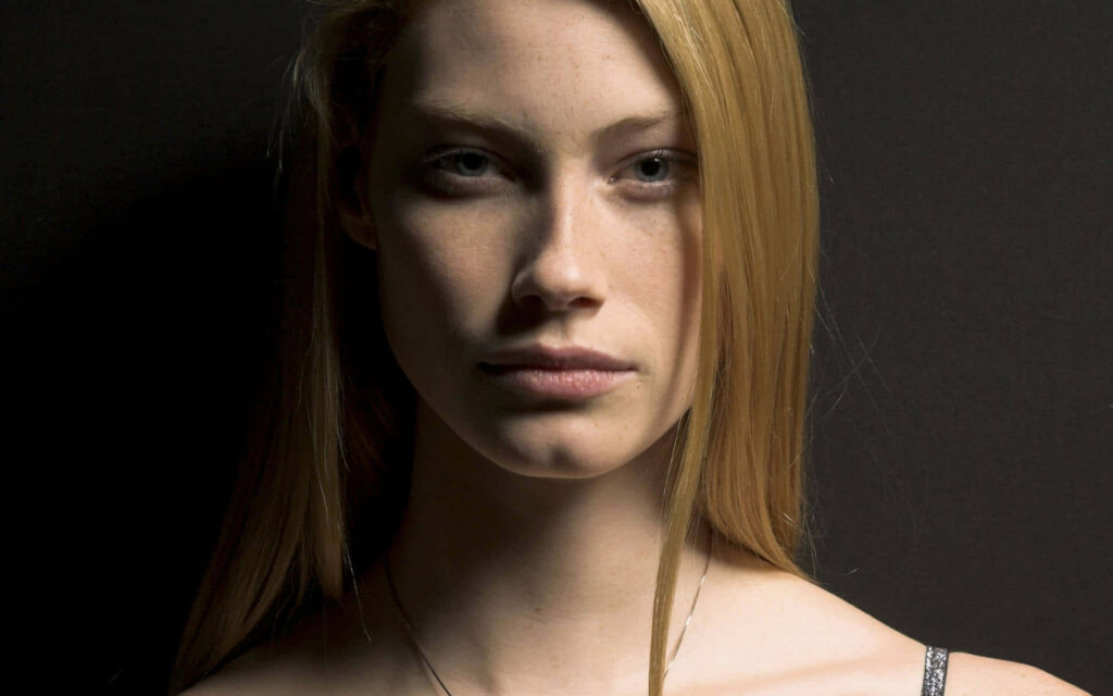 Alyssa Sutherland intense focused gaze sharp features confident pose dark background wallpaper
