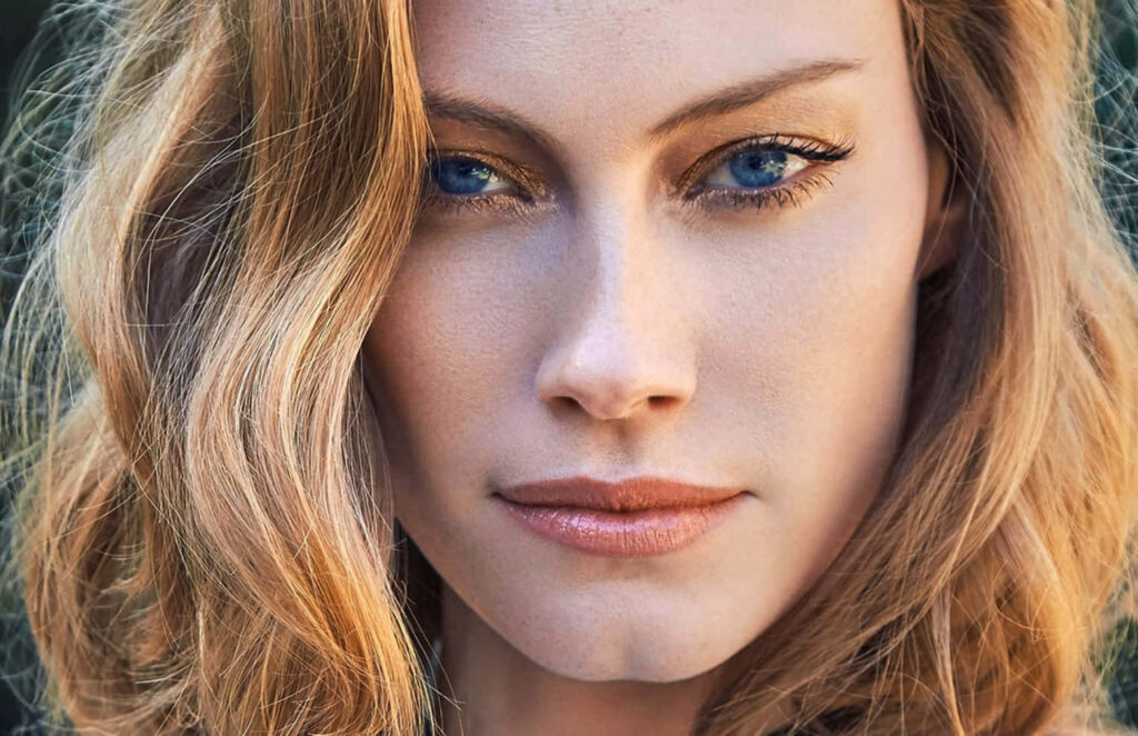 Alyssa Sutherland portrait with intense blue eyes soft wavy hair elegant wallpaper background