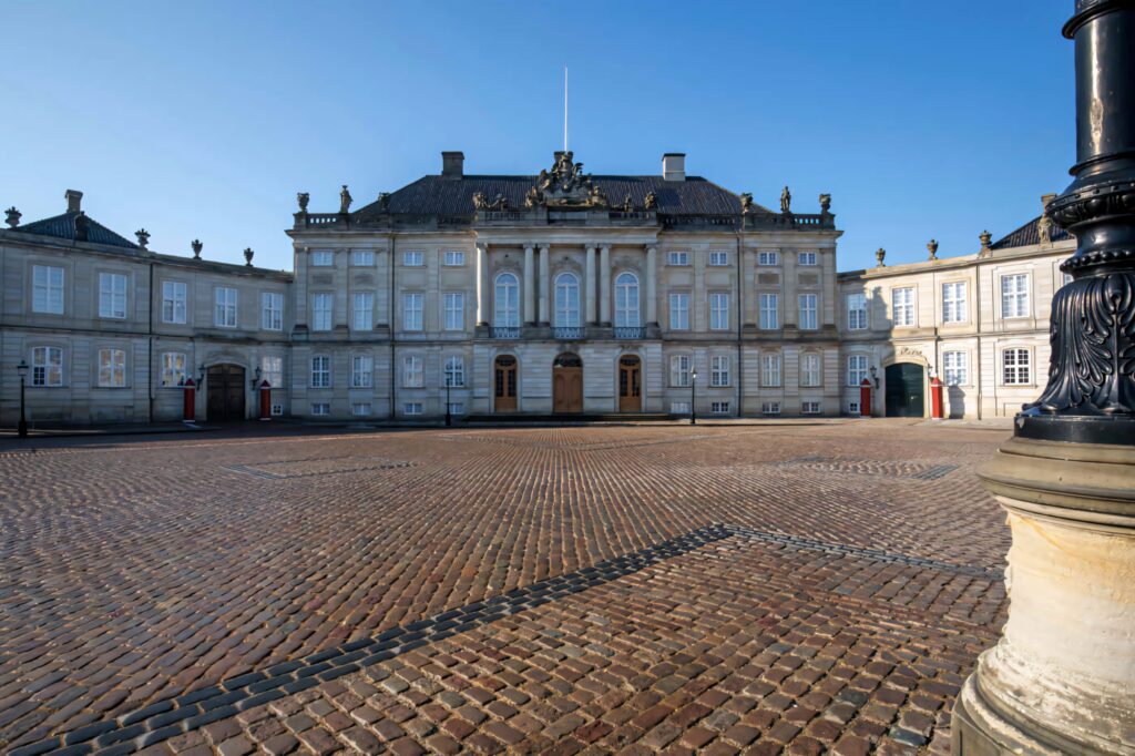 Amalienborg Palace neoclassical architecture with cobblestone courtyard under clear blue sky Wallpaper