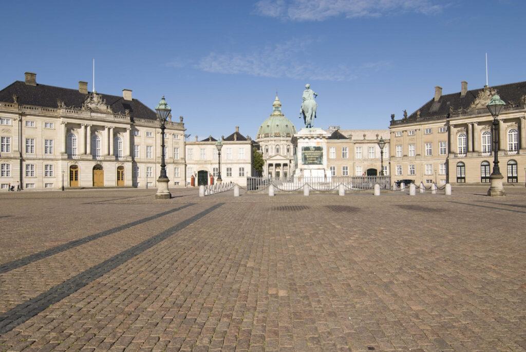 Amalienborg Palace classical buildings and central statue under clear blue sky wallpaper background