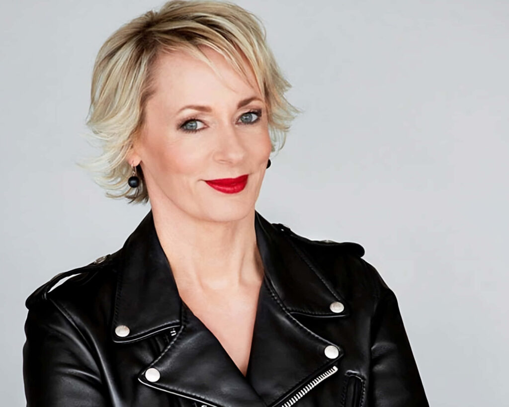Amanda Keller confident in chic black leather jacket portrait on soft neutral wallpaper background