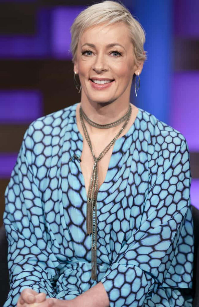 Amanda Keller smiling in stylish blue patterned outfit with soft light vibrant professional backdrop Wallpaper