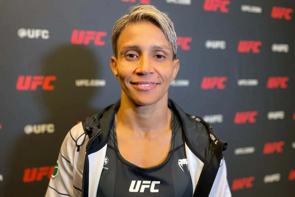 Amanda Lemos confident UFC fighter smiling with branded backdrop wallpaper background image