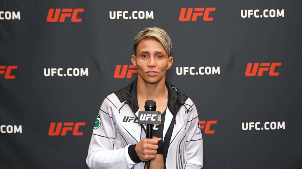 Amanda Lemos UFC fighter interview focused determined holding microphone front UFC backdrop wallpaper