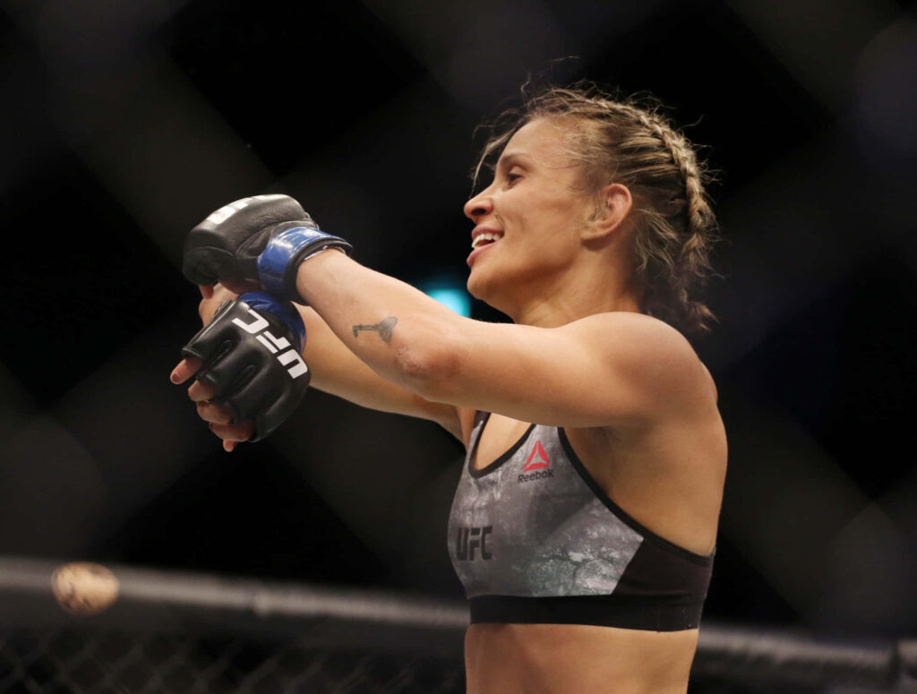 Amanda Lemos celebrates MMA victory in the octagon showing strength and triumph wallpaper