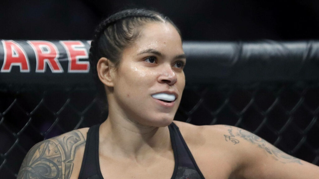 Amanda Nunes inside MMA cage with white teeth guard showing fierce focused expression wallpaper