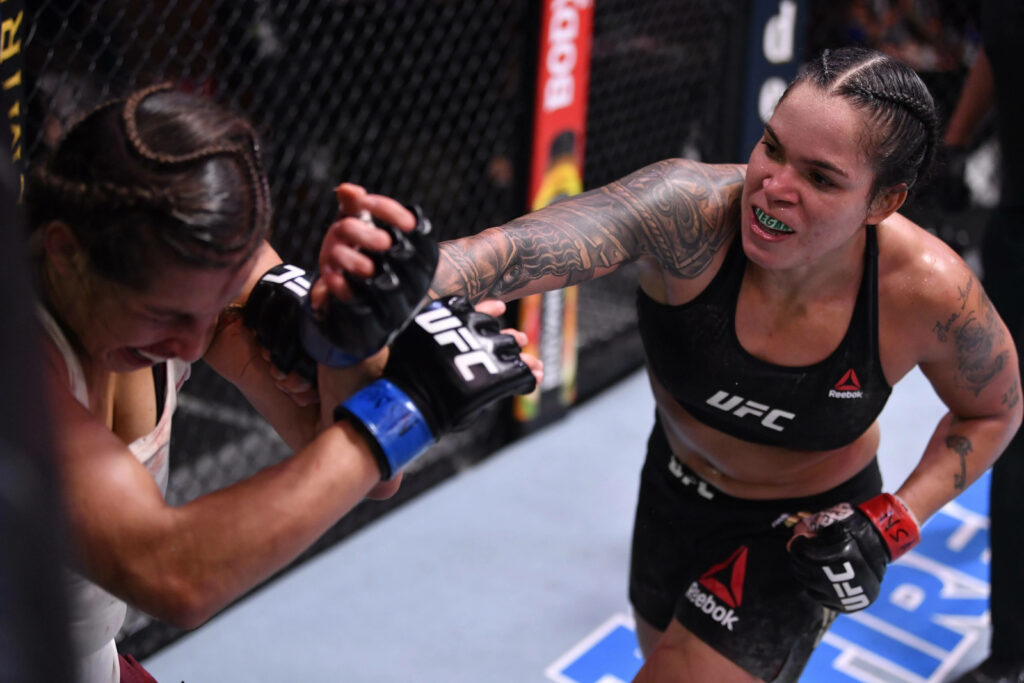 Amanda Nunes delivers a powerful punch in UFC match showing fierce fighting style dominance Wallpaper