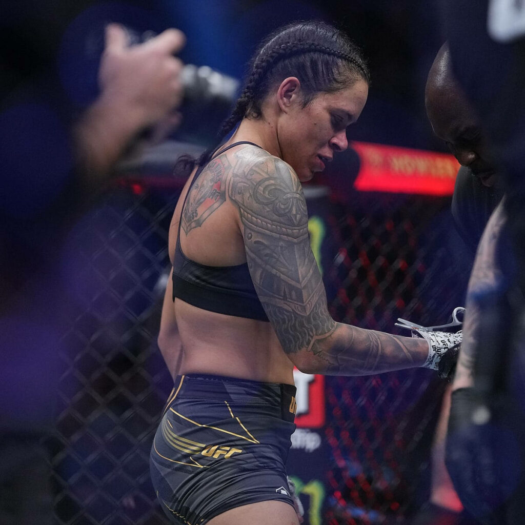 Amanda Nunes UFC cage fight wallpaper showing detailed arm tattoo and intense fight focus