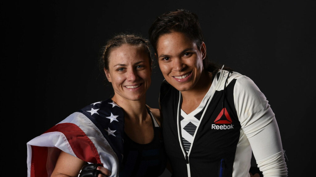 Amanda Nunes and Nina Ansaroff smiling together Amanda in UFC jacket Nina with American flag Wallpaper