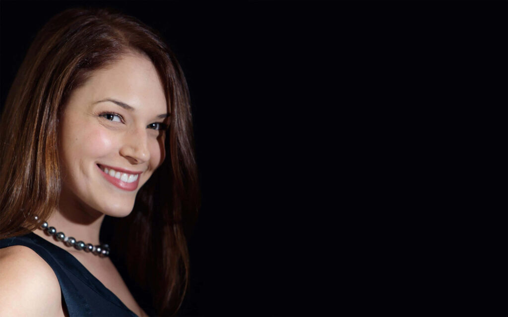 Amanda Righetti radiant smile pearl necklace elegant portrait sleek black background wallpaper