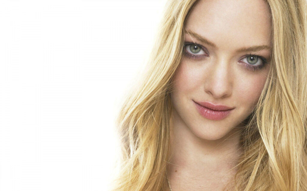Close-up portrait of Amanda Seyfried with soft blonde hair and gentle expression on white background Wallpaper