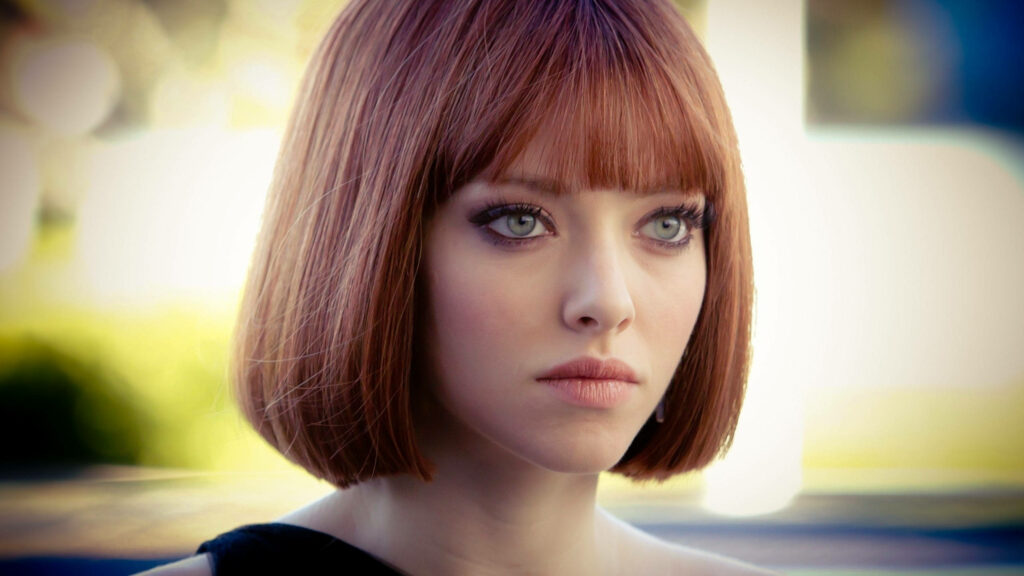 Amanda Seyfried with sleek short bob hairstyle and modern sophisticated look on wallpaper background