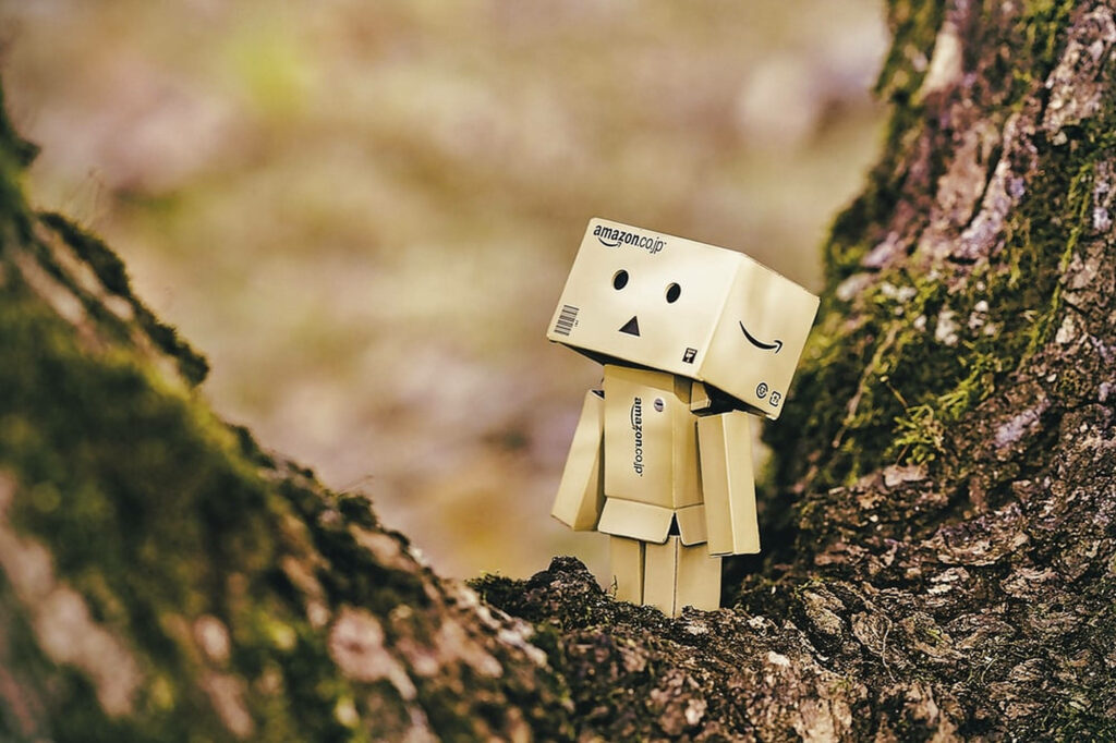 Amazon Boxman figure by textured tree bark in soft natural light with green foliage background Wallpaper