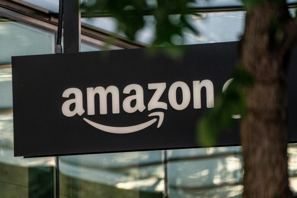 Sleek Amazon UK sign near tree blending modern branding with natural outdoor wallpaper background