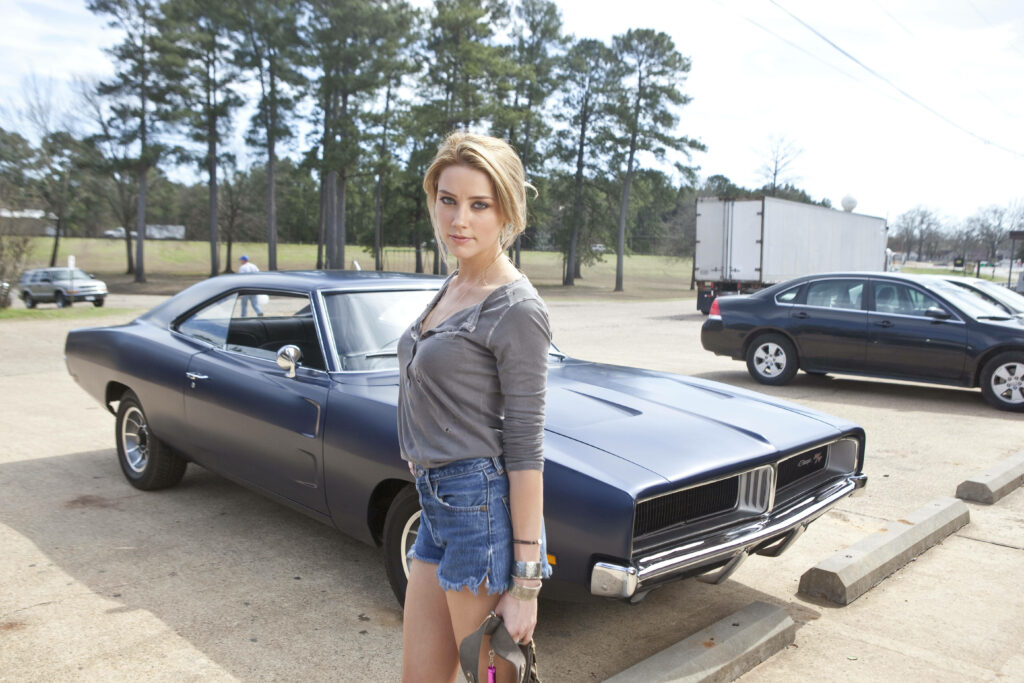 Amber Heard confidently poses by classic muscle car in action-packed Drive Angry movie scene wallpaper