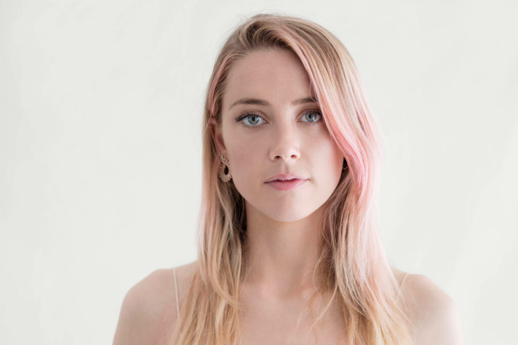 Amber Heard with soft pink hair highlights standing against plain white minimalistic background Wallpaper