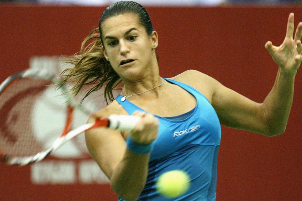 Amélie Mauresmo focused tennis player preparing to hit ball showcasing skill and determination Wallpaper