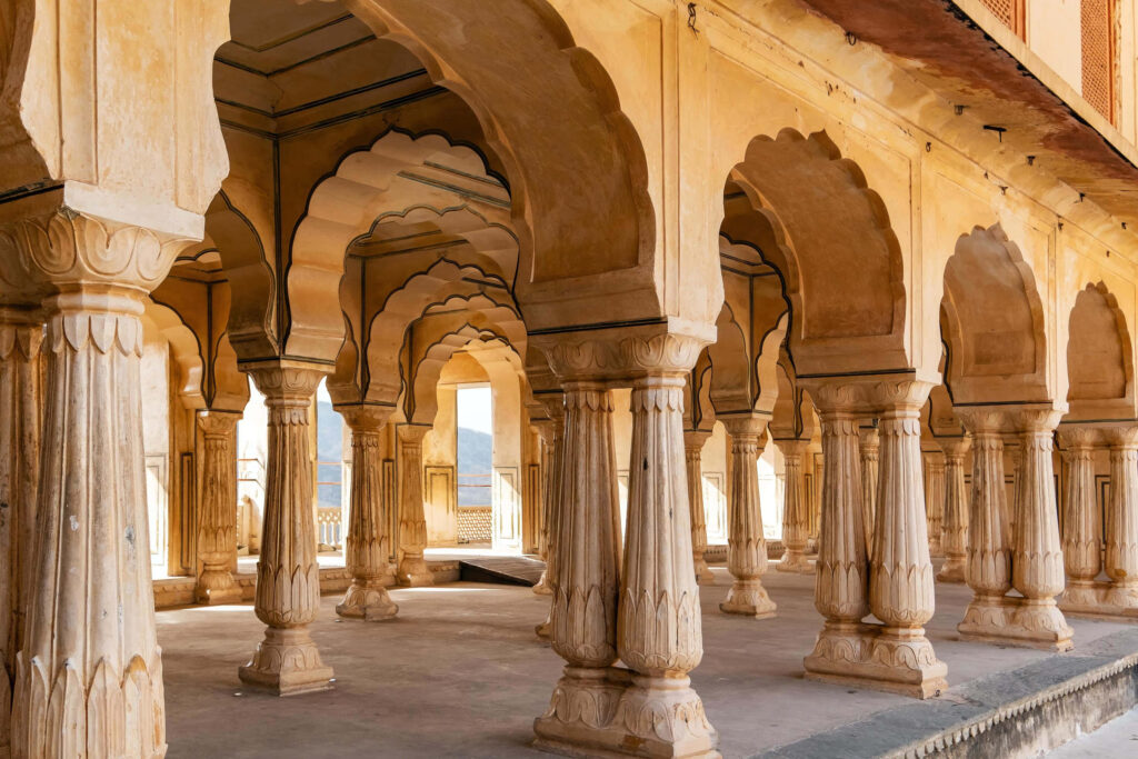 Intricate architecture and grand arches with elegant pillars inside Amer Fort Rajasthan wallpaper