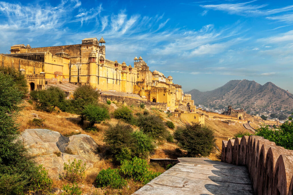 Amer Fort Rajasthan architecture with bright blue sky and rugged hills wallpaper background