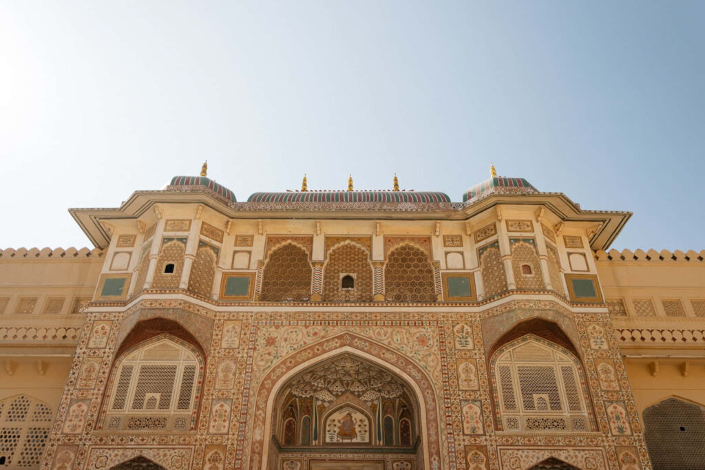 Amer Fort facade with intricate white marble carvings showcasing Rajasthani architecture background Wallpaper