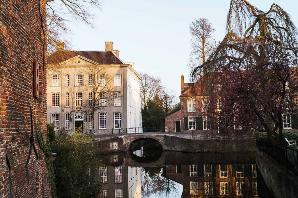 Historic Amersfoort buildings reflected in calm canal at sunset serene cityscape wallpaper background