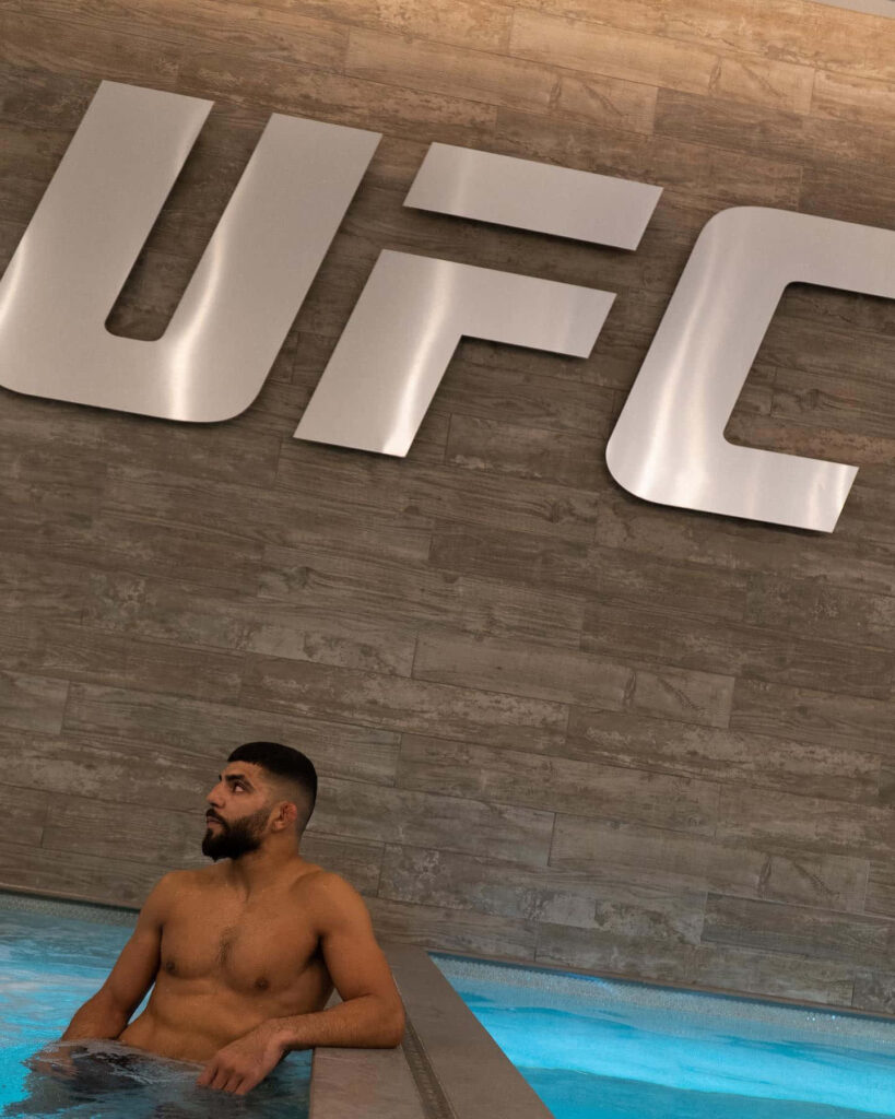 Amir Albazi relaxing in pool under UFC logo calming training scene wallpaper background