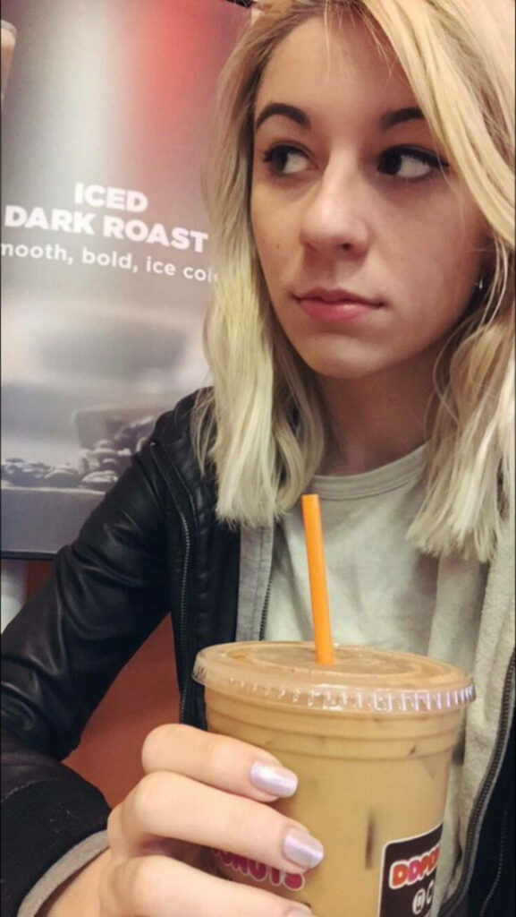 Amy Nelson enjoying a refreshing iced coffee in a relaxed cozy setting perfect for coffee lovers Wallpaper