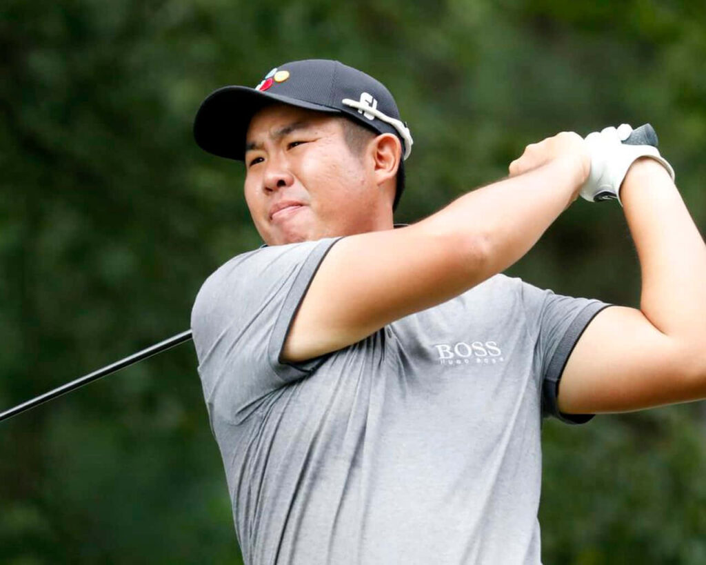 An Byeong-hun mid golf swing focused athletic form dynamic motion green blurred background wallpaper