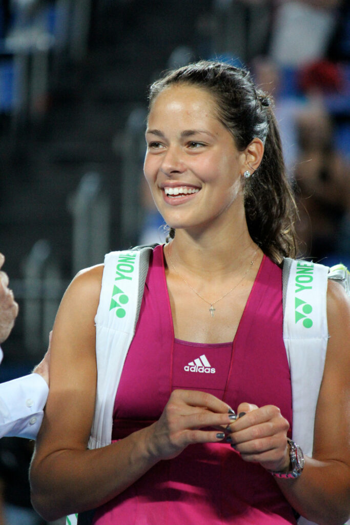 Ana Ivanović smiling confidently in tennis attire after winning on the court wallpaper background