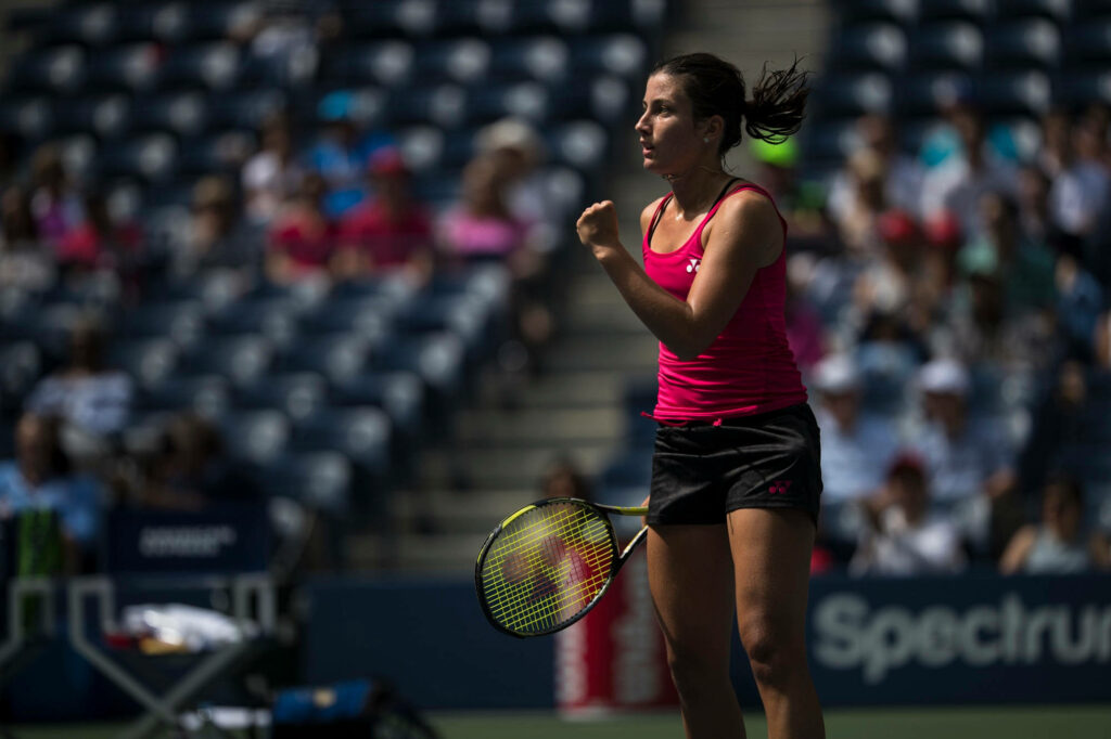 Anastasija Sevastova determined fist pump during intense tennis match action on court wallpaper