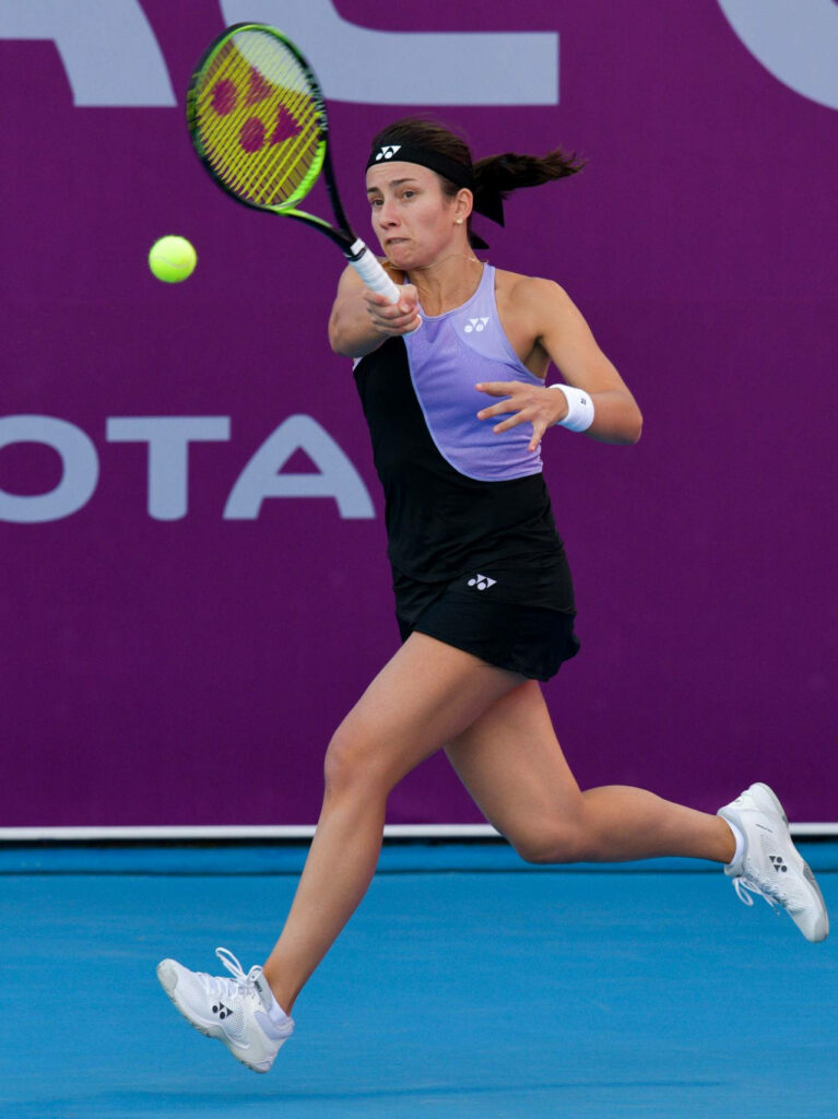 Anastasija Sevastova sprinting on tennis court focused preparing to return ball intense match Wallpaper
