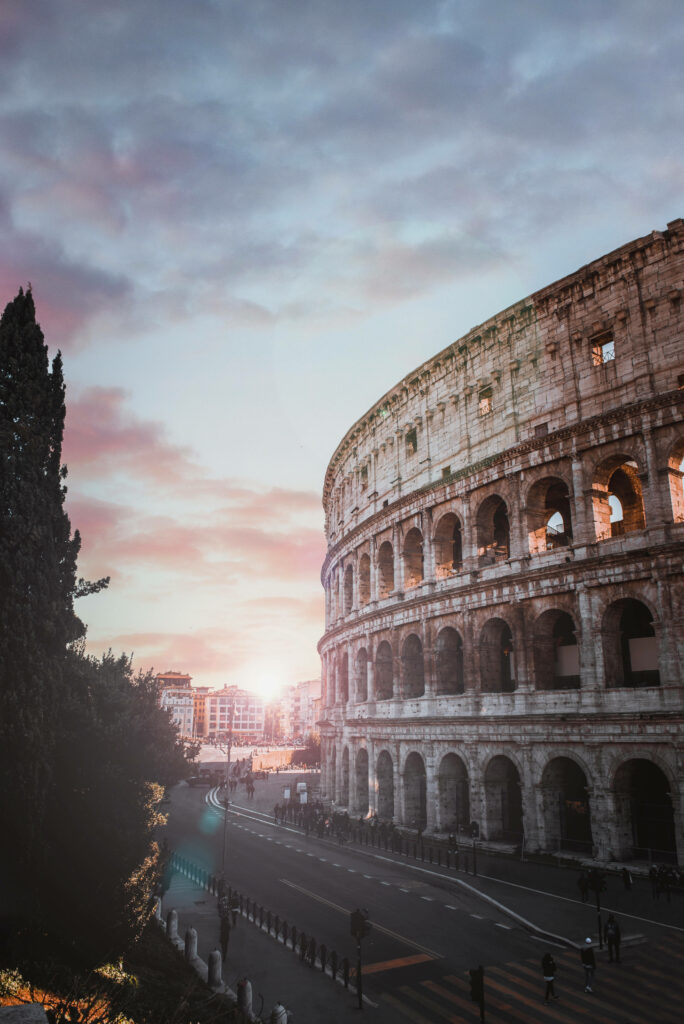 Ancient Colosseum under dramatic cloudy sky with moody light historic stone structure wallpaper