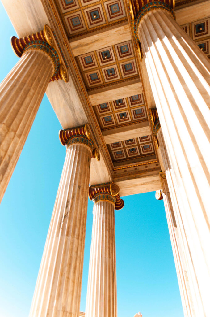 Low-angle view of ancient Greek pillars in Athens with clear blue sky classical architecture Wallpaper