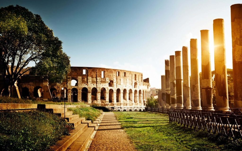 Ancient Roman Colosseum park wallpaper with golden sunlight lush greenery and historic columns